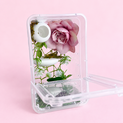 Front-opening juvenile jumping spider enclosure with the door open, showing the pink rose decor, greenery, and moss