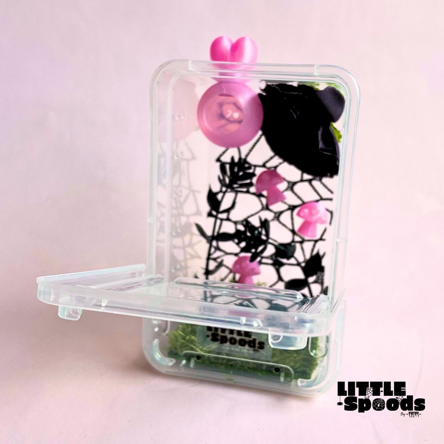 Pink juvenile jumping spider enclosure with front-opening door, magnetic hide, floral décor, and plenty of climbing space.
