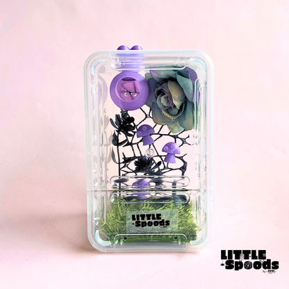 Purple handmade whimsical gothic juvenile jumping spider enclosure featuring magnetic hide, flowers, mushrooms, and cross ventilation.